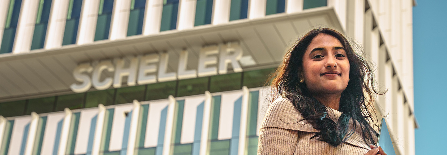 hero banner of the George Tower | Scheller Tower and student standing in front
