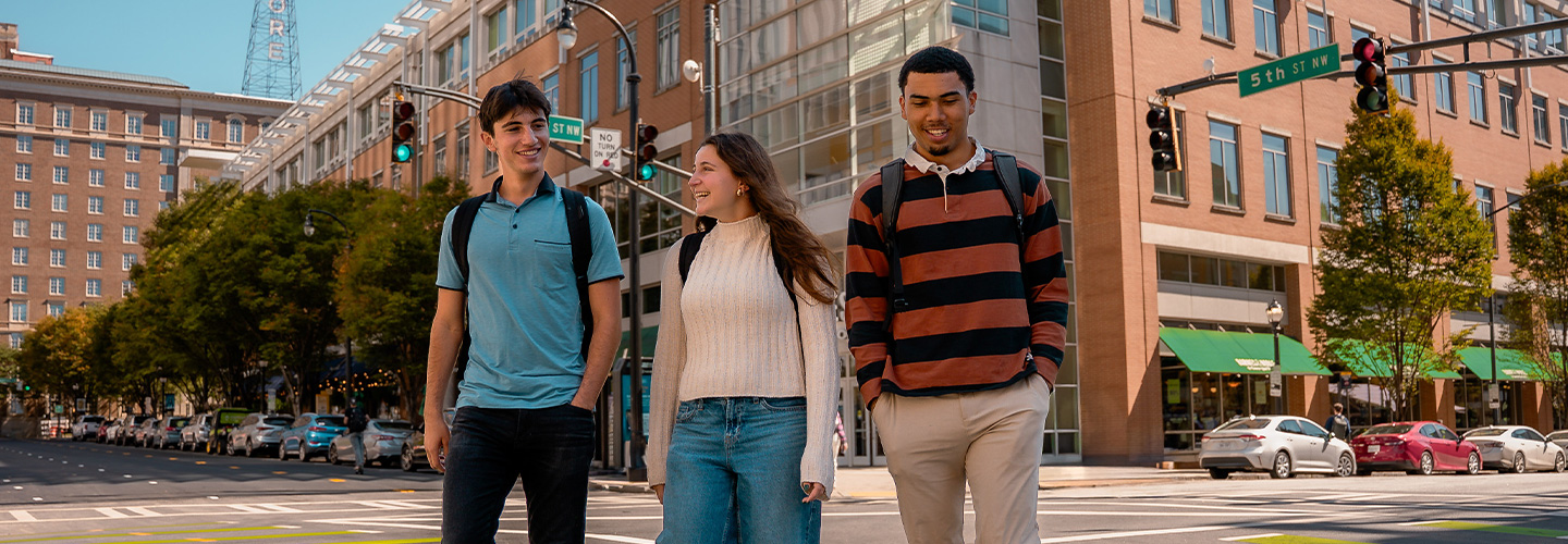 Three students crossing an intersection in front of the bookstore at Technology Square